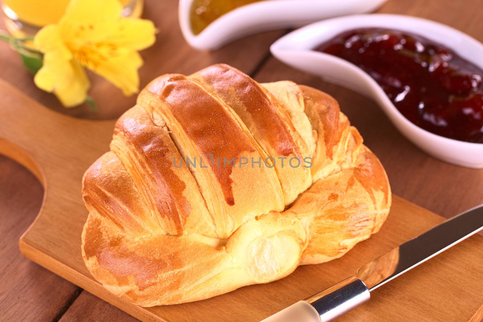 Croissant and strawberry jam (Selective Focus, Focus on the front of the croissant)