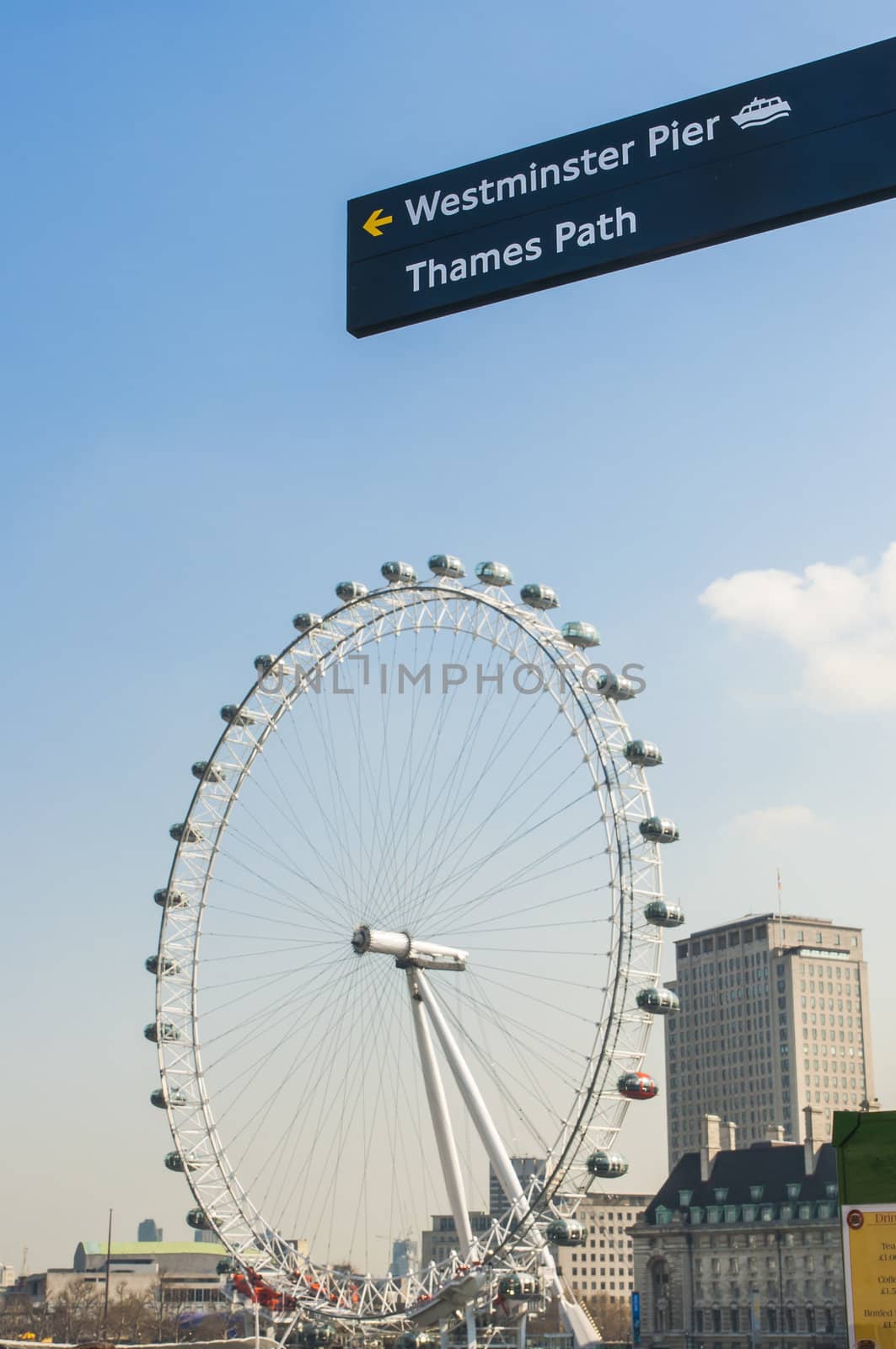 LONDON, UK - APRIL 02: Sign post directing to famous tourist attractions, with London Eye in the background . April 02, 2012 in London.