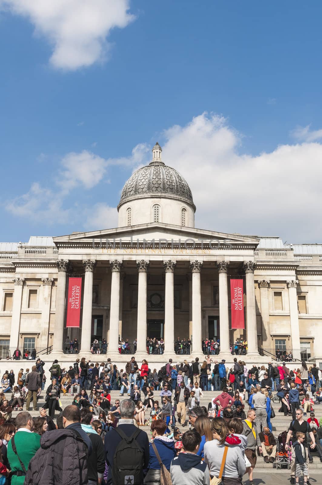 LONDON, UK - APRIL 02: Facade of The National Gallery in Trafalgar Square, with public enjoying the sun. April 02, 2012 in London.