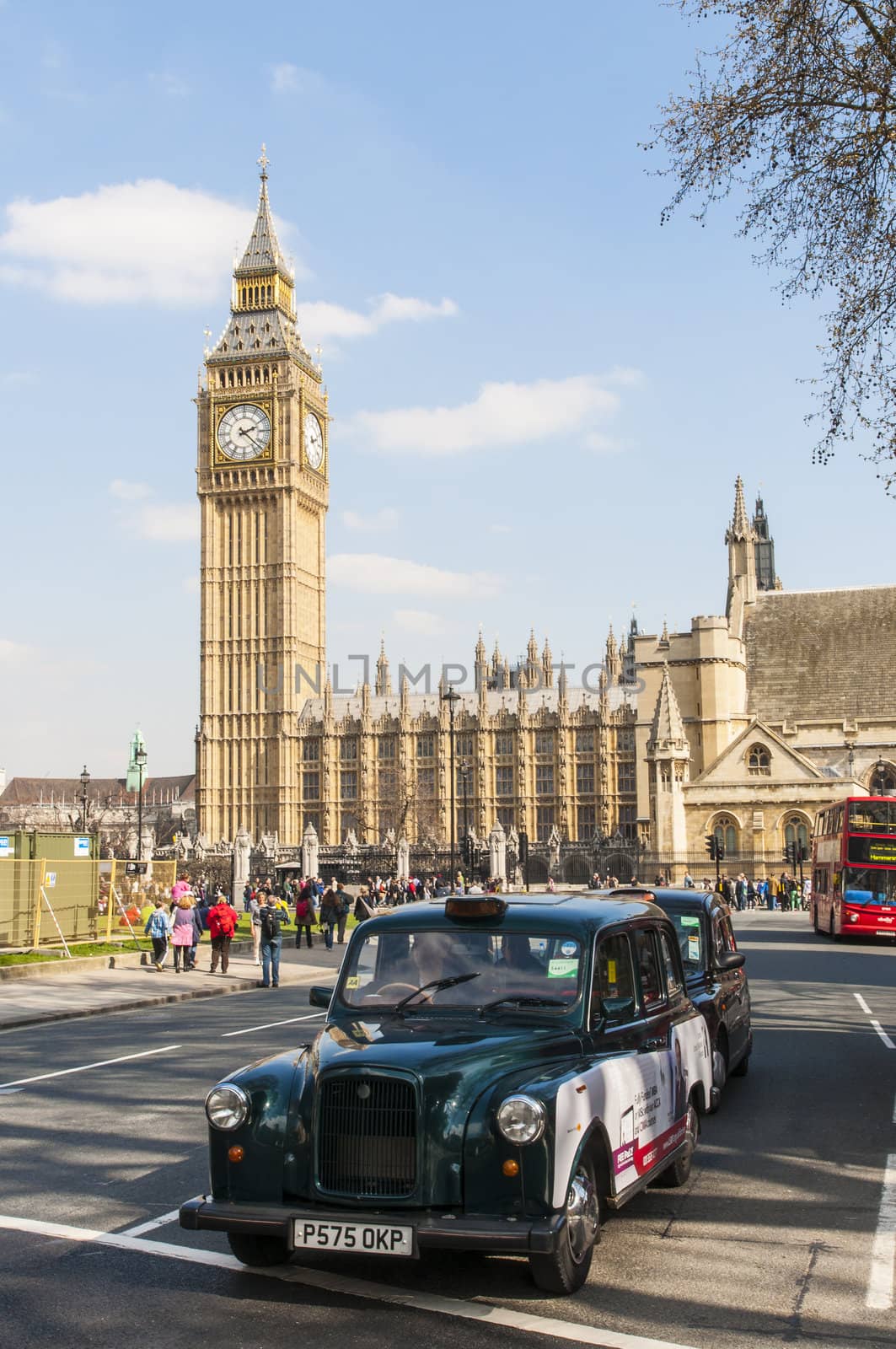 LONDON, UK - APRIL 02: Famous black cab driving by Houses of Parliament, with Big Ben prominent in the picture. April 02, 2012 in London.