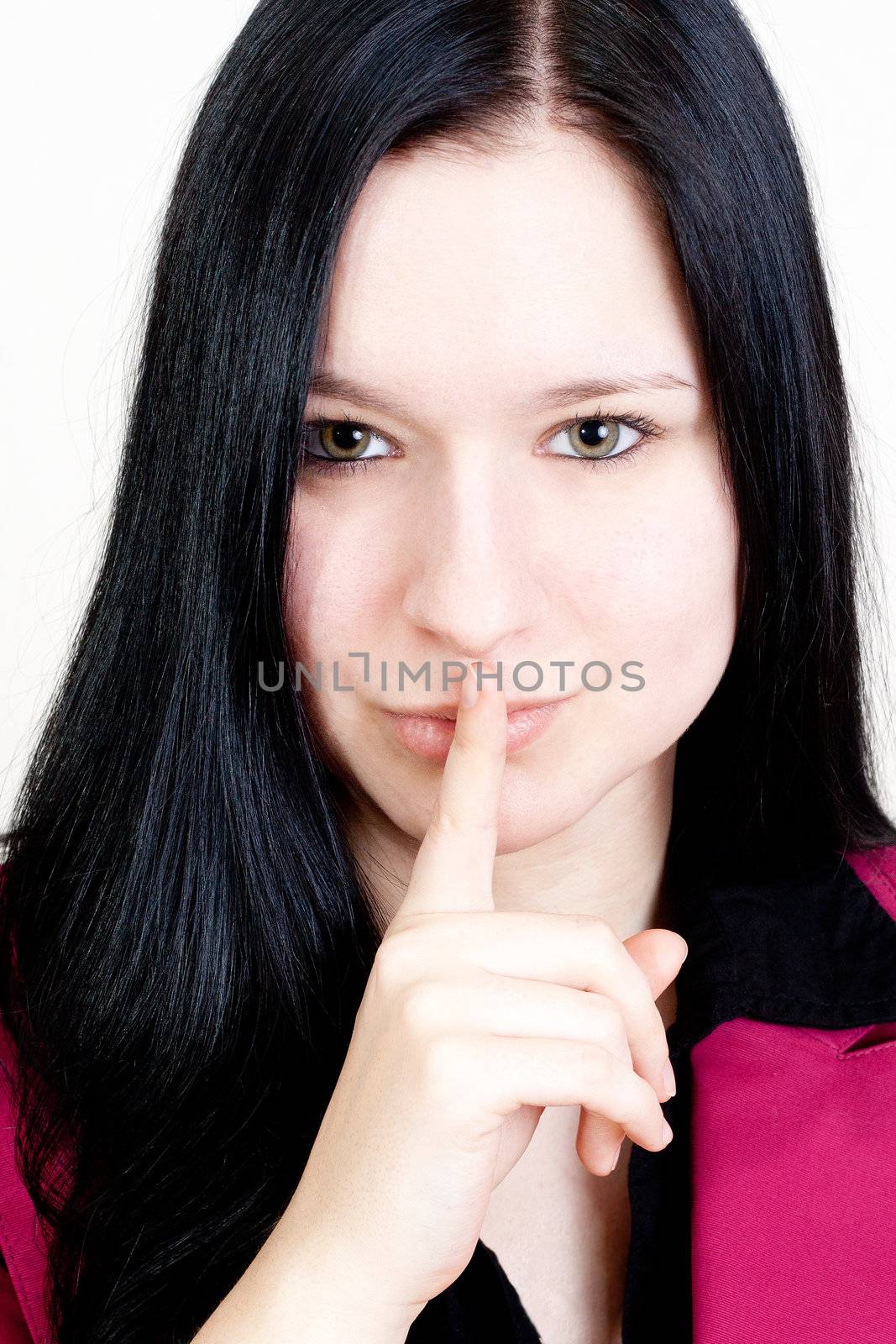 Black haired Girl holding her forefinger on her lips.