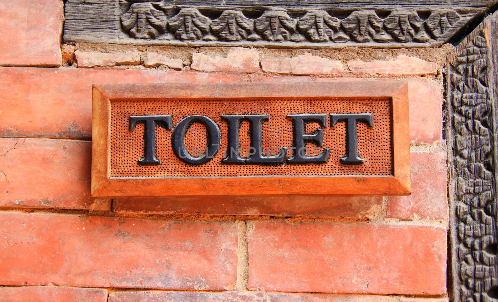 Ancient toilet sign on brick wall by nuchylee