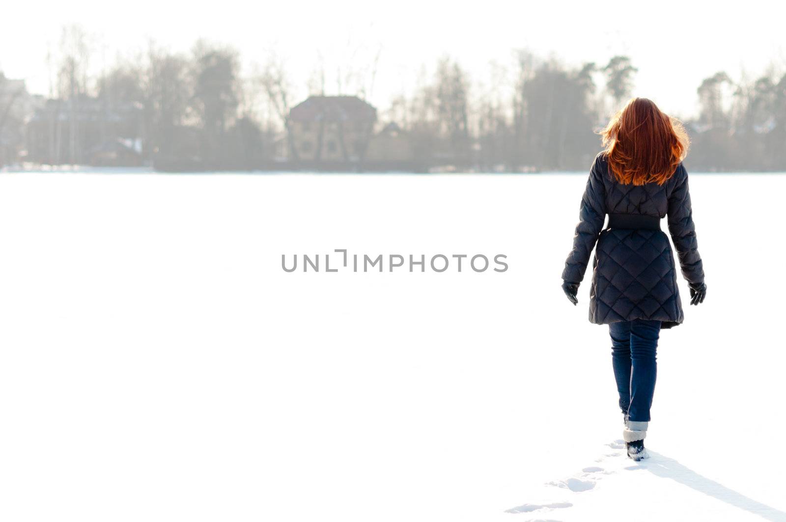 Pretty girl walking on frozen lake by dmitryelagin