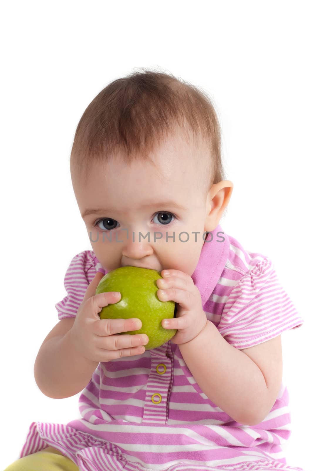 Shot of baby girl on pink eating apple