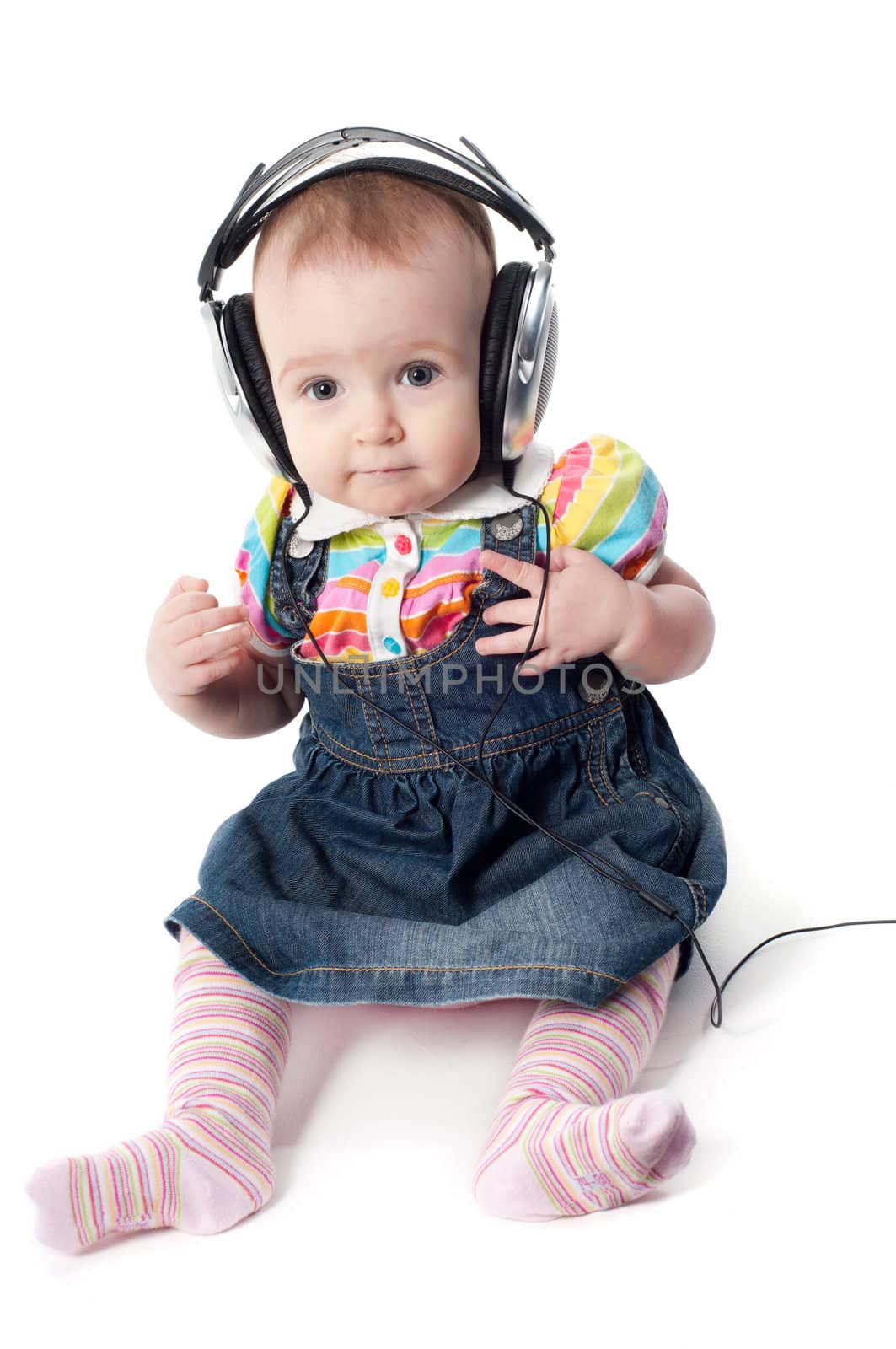 Studio shot of little cute baby in headphones girl