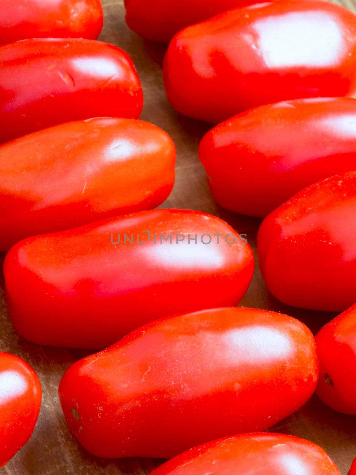 close up of roma tomatoes on wooden table