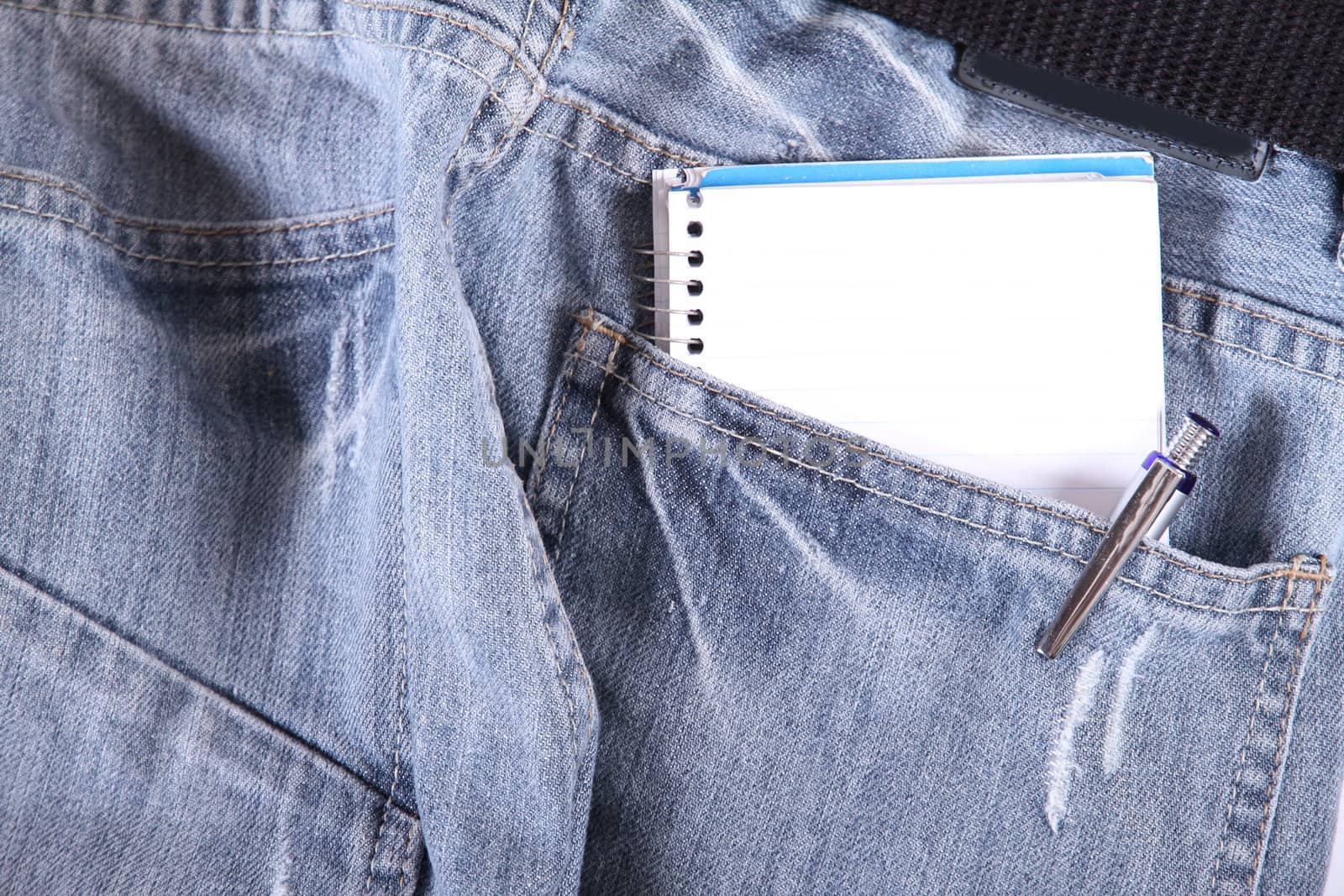 A notebook in some jeans trousers.