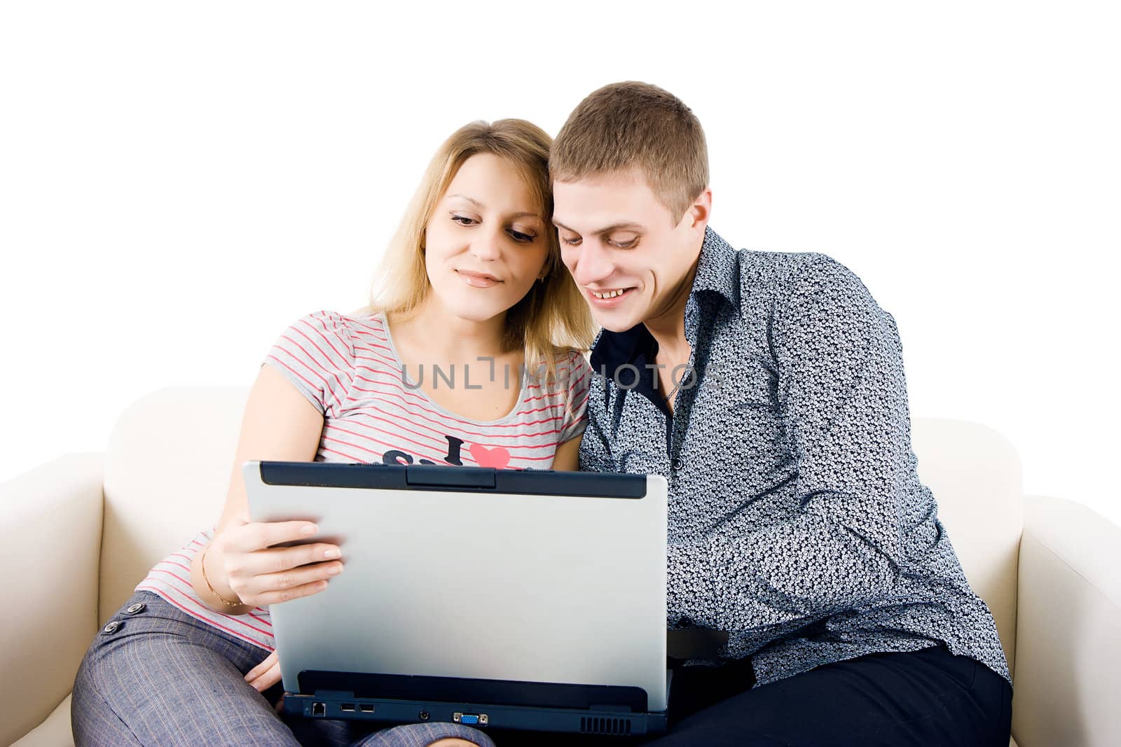 Happy young couple with a laptop sitting on the couch