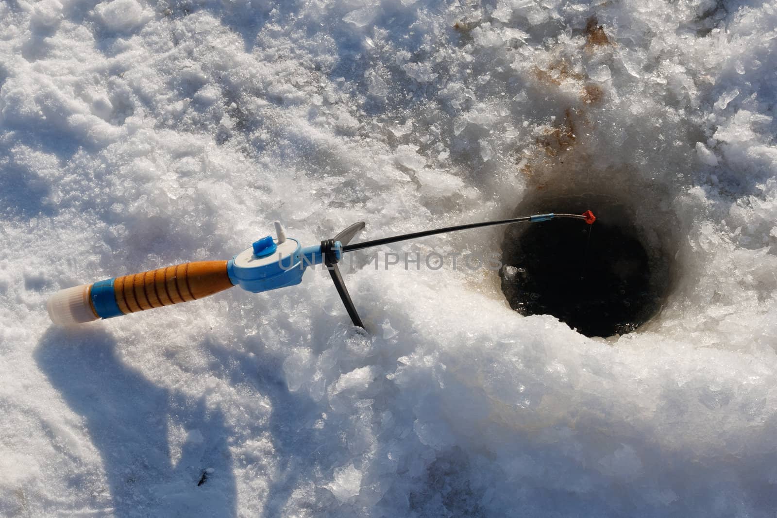 Winter fishing rod and hole in the ice