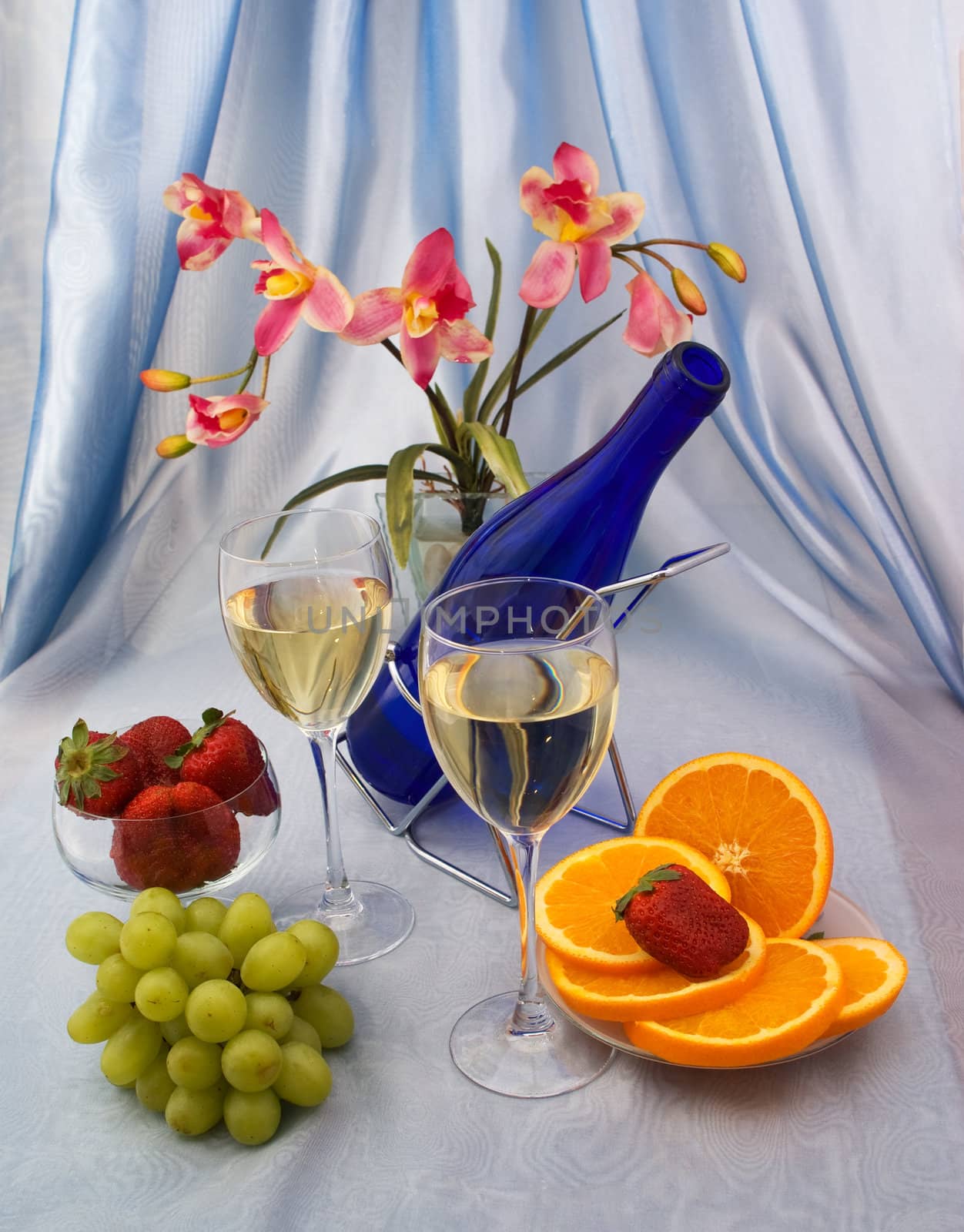 Glasses of wine with fruit and orchid