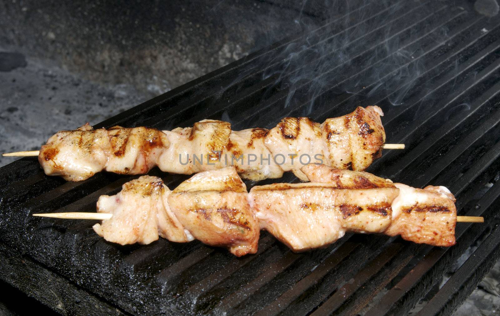 cooking skewers of chicken on the grill