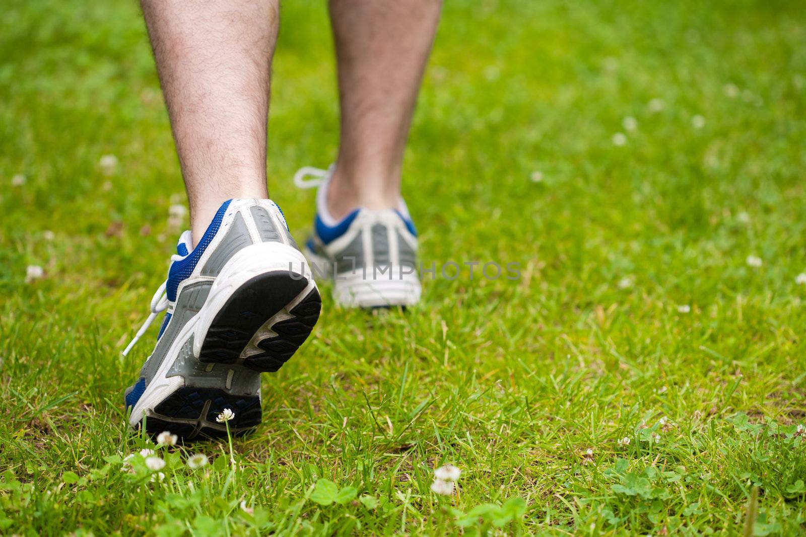 legs of walking man on grass