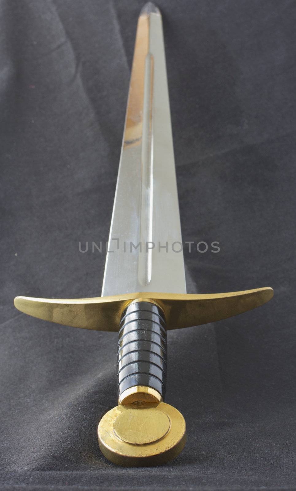 Long medieval metal sword, with golden decoration on the hilt