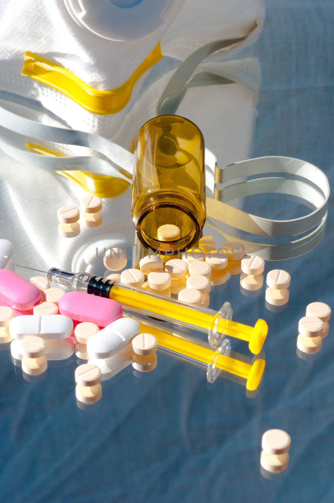 Medicine bottle and syringe and mask with pills and reflection