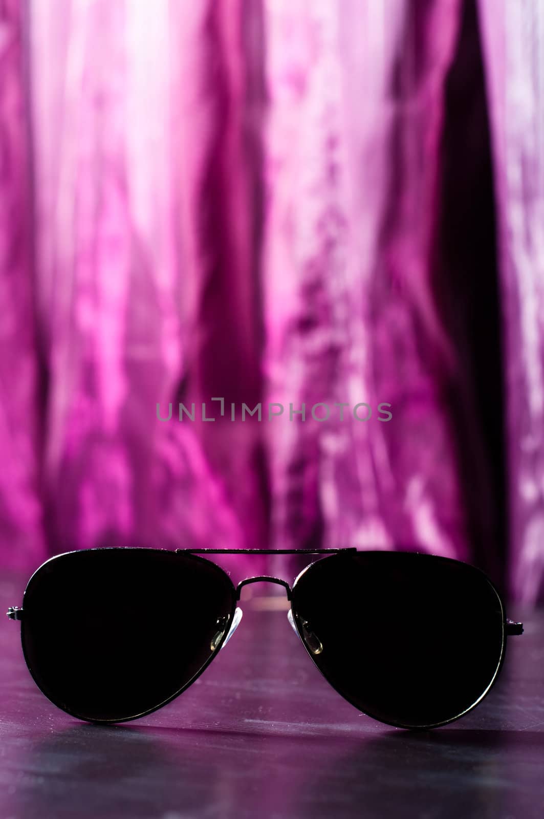 Sunglasses against purple blurry background