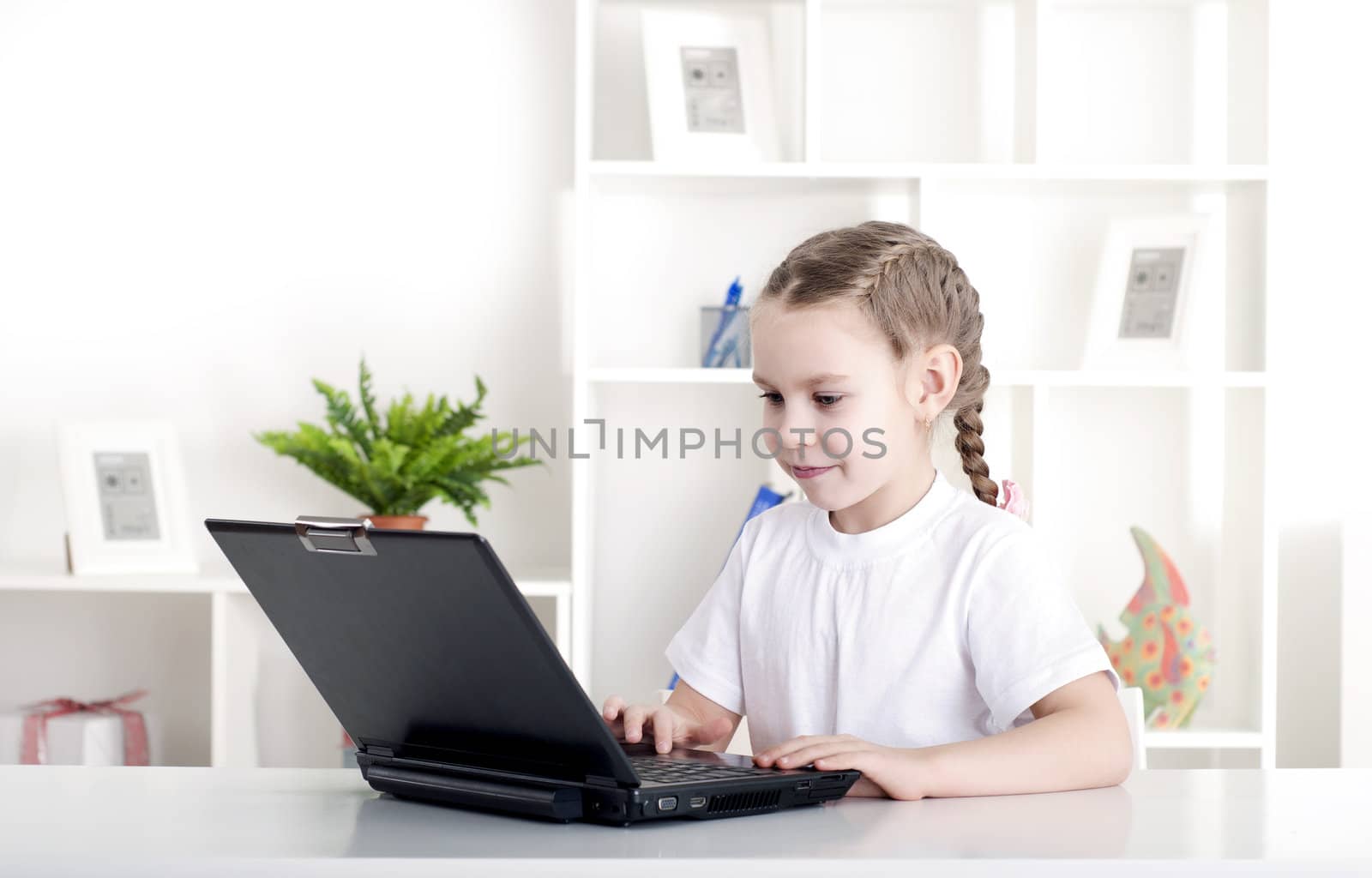 girl working on laptop at home, sitting at the table