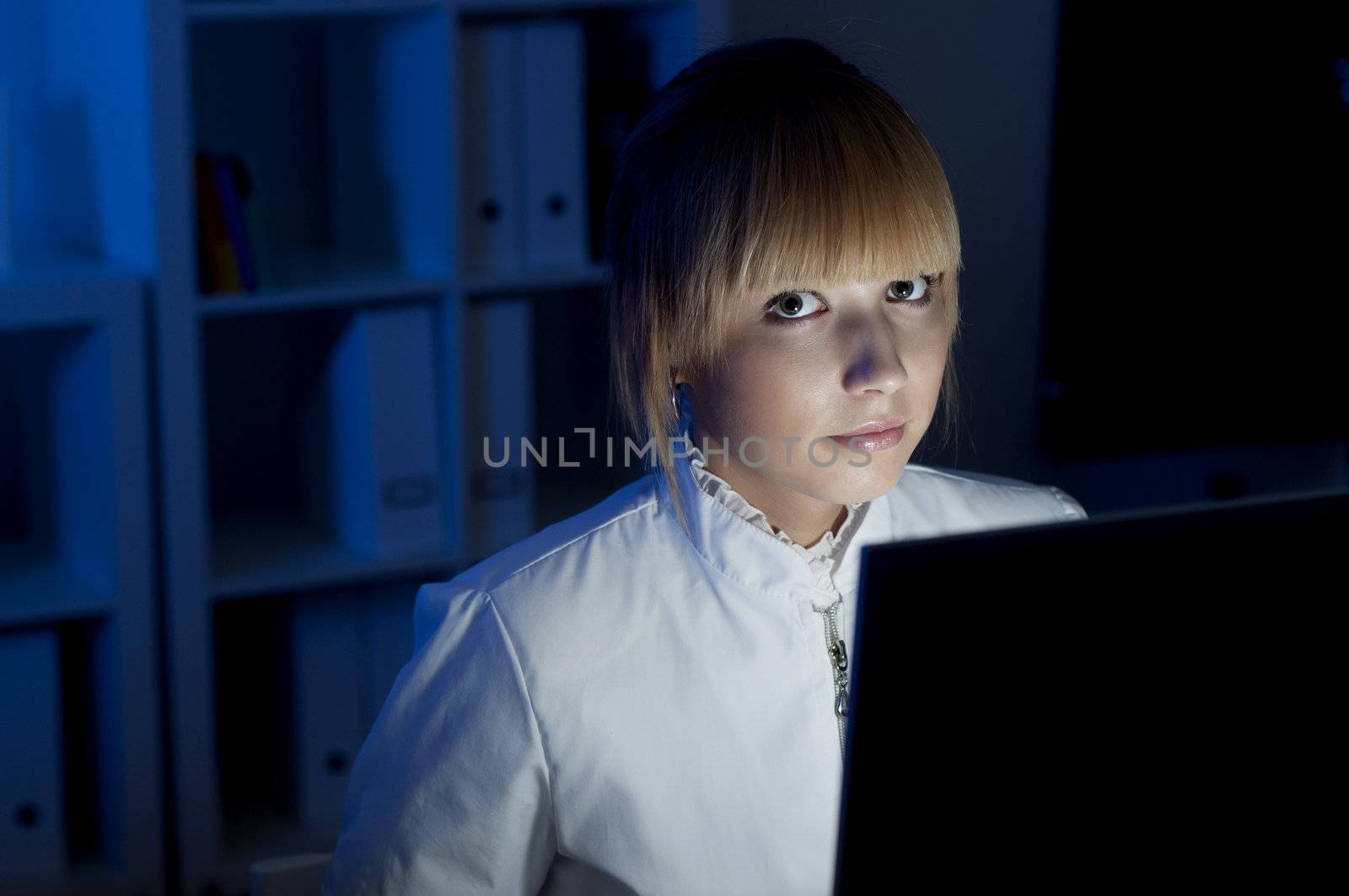 beautiful young woman doctor working at night in the office, smiling