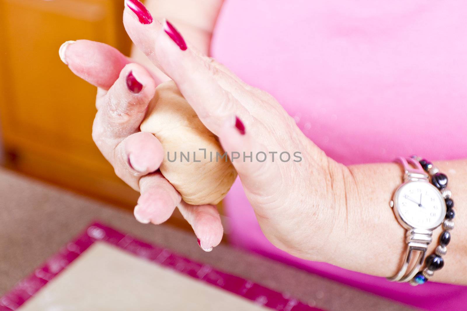 Experienced older female hands are hand rolling the dough.