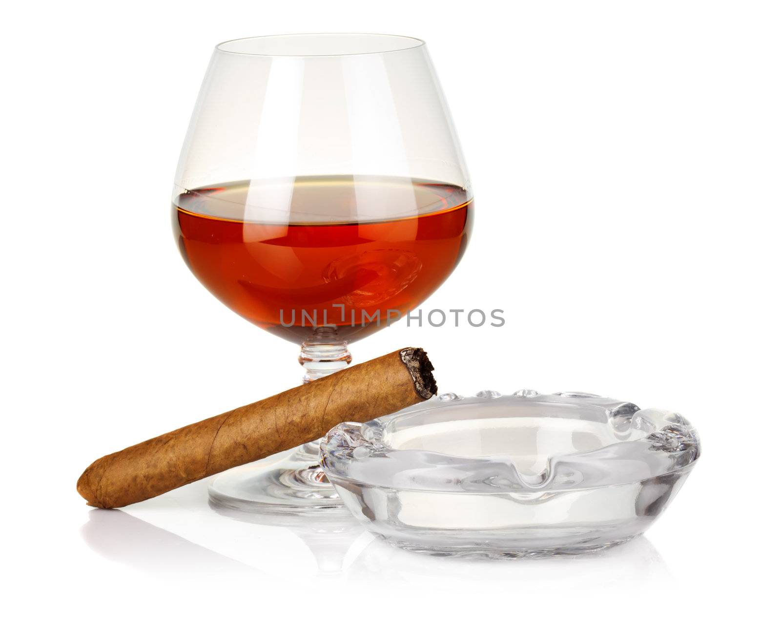 Cognac in glass with cigar and ashtray isolated by alphacell