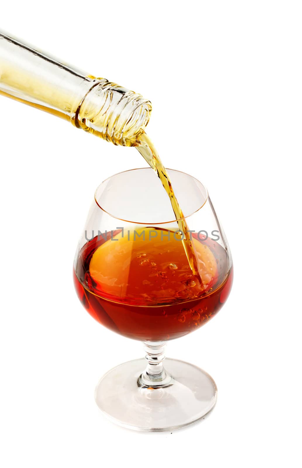 Filling a glass of brandy isolated on white by alphacell