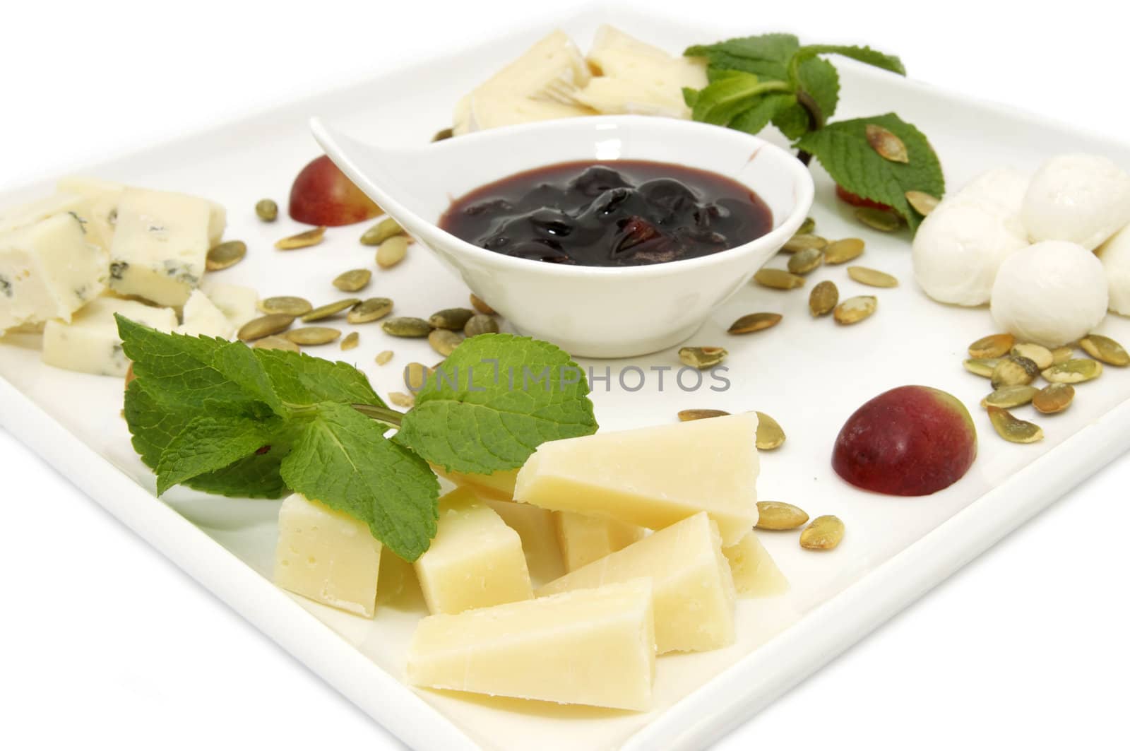 a plate of cheese decorated with berries and mint