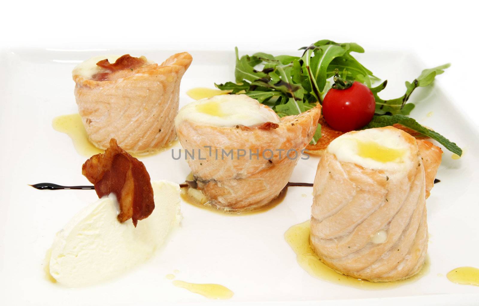 grilled fillet of fish with greens and tomato on a white background