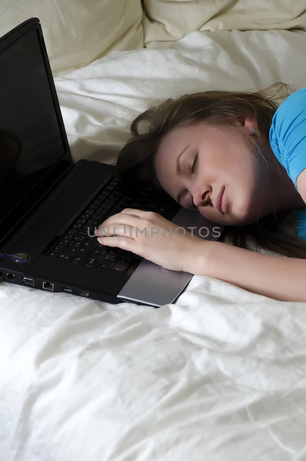 Young girl student was tired and fell asleep on a laptop