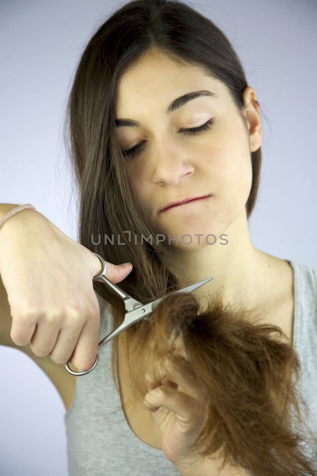 girl cuts her long hair very unhappy and angry