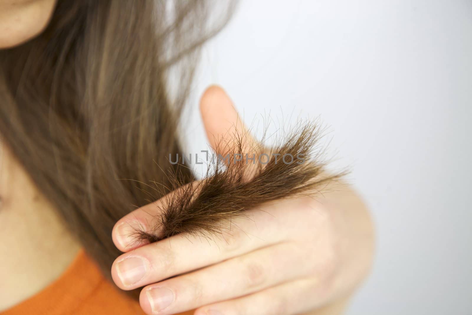 Split ends hair of brunette female model holding hand