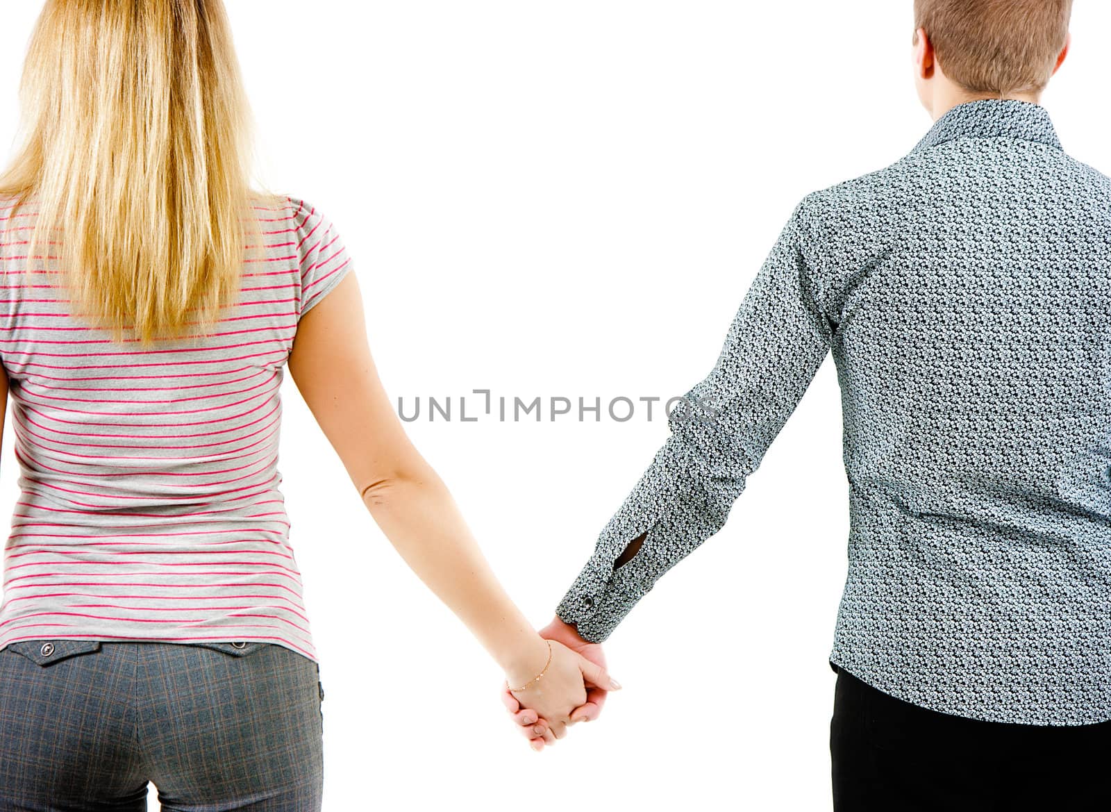 A young couple holding each other's hands. View from the back