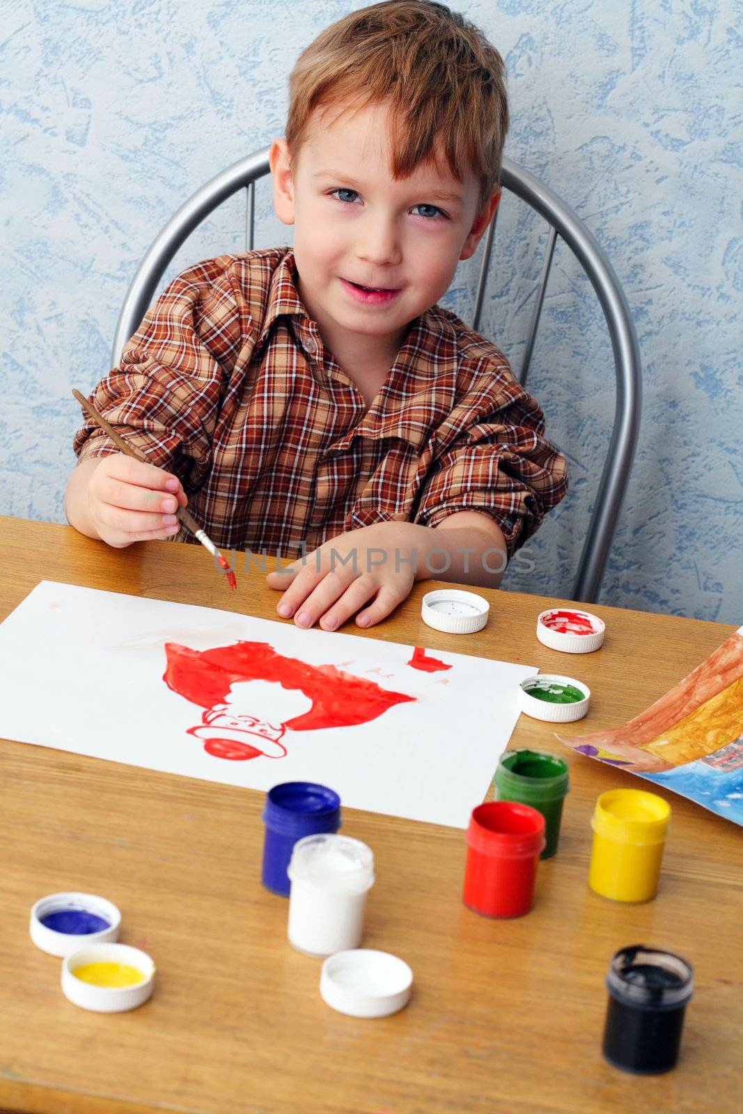 boy paints a Christmas picture