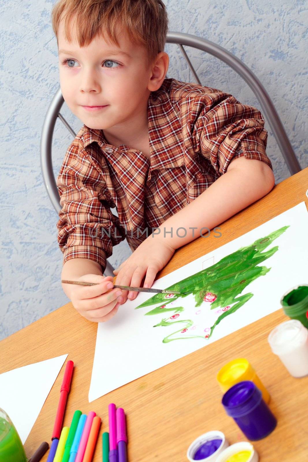 boy paints a Christmas picture