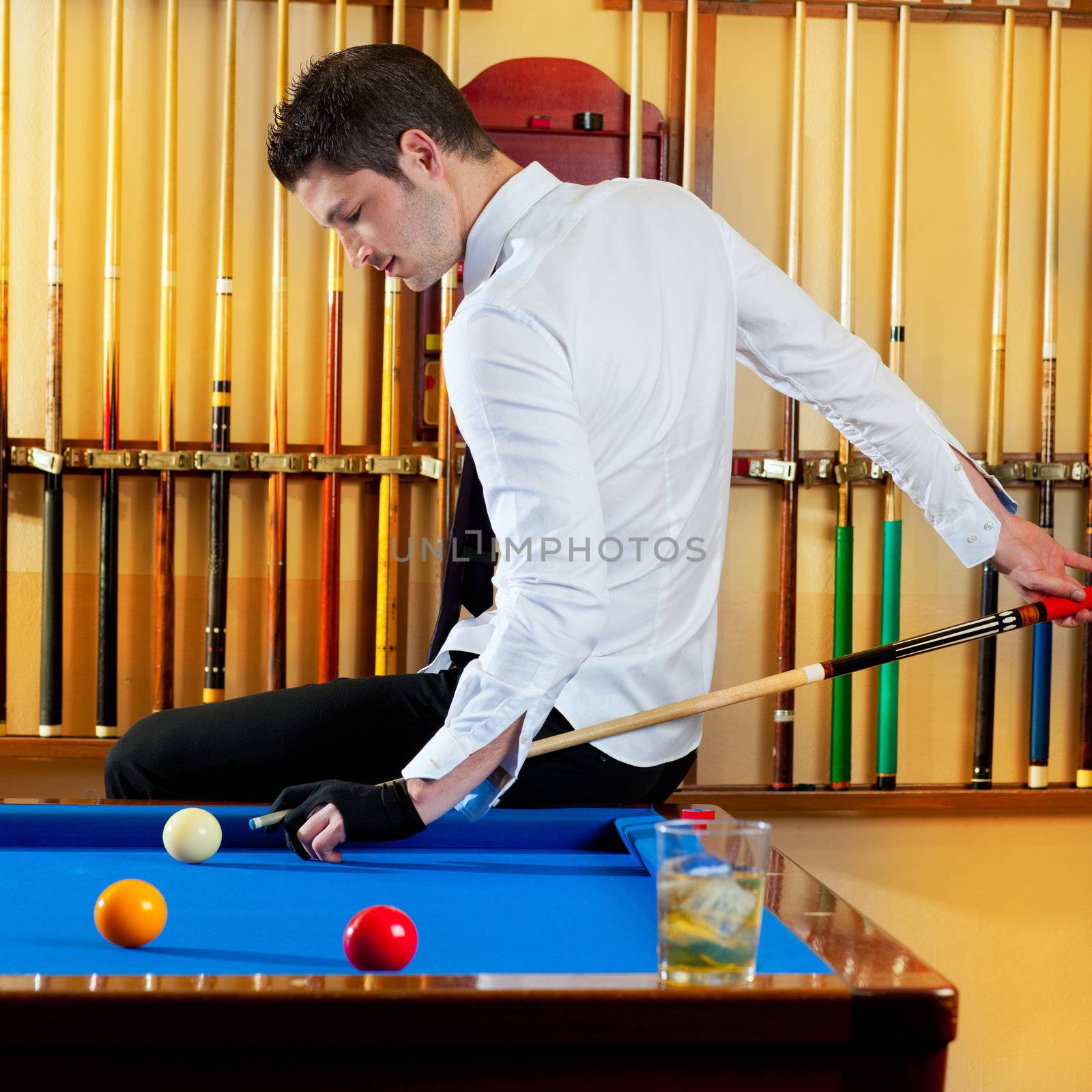 Billiard winner handsome man playing with cue and balls at club