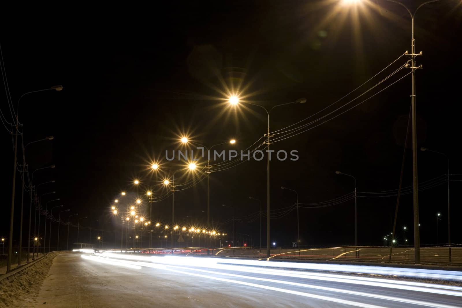 Night street with traces from light of headlights shined with street lanterns