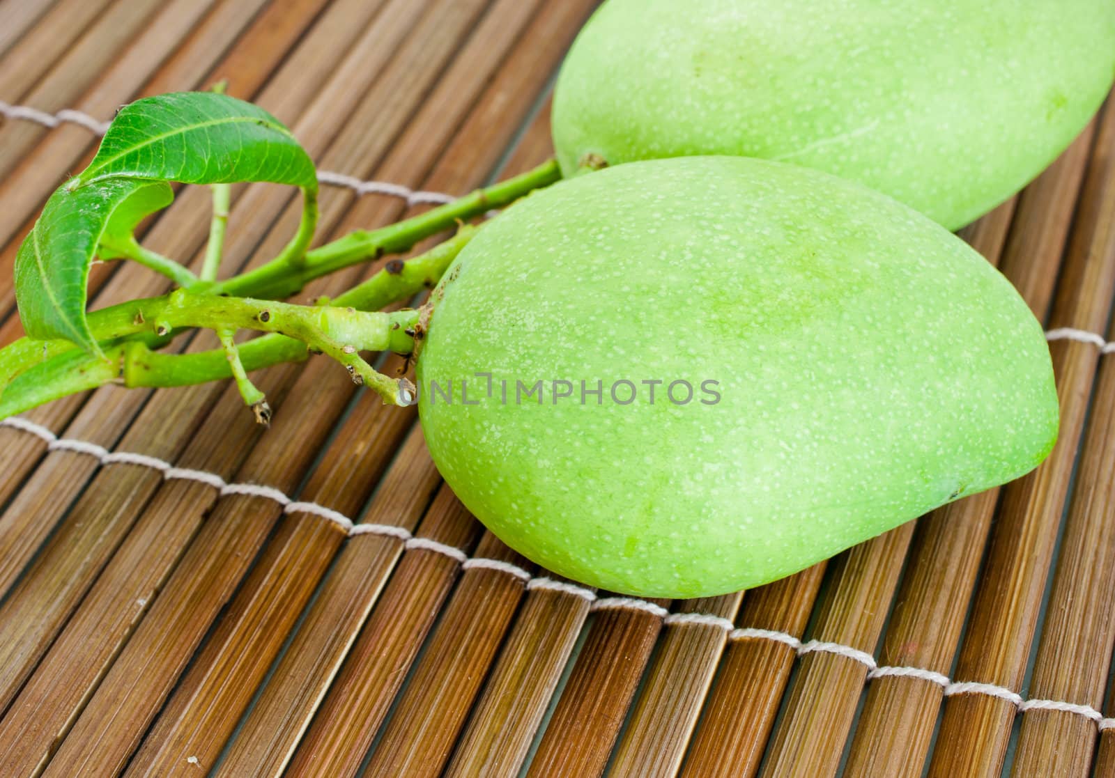 Geen mango fruit  macro on bamboo floor