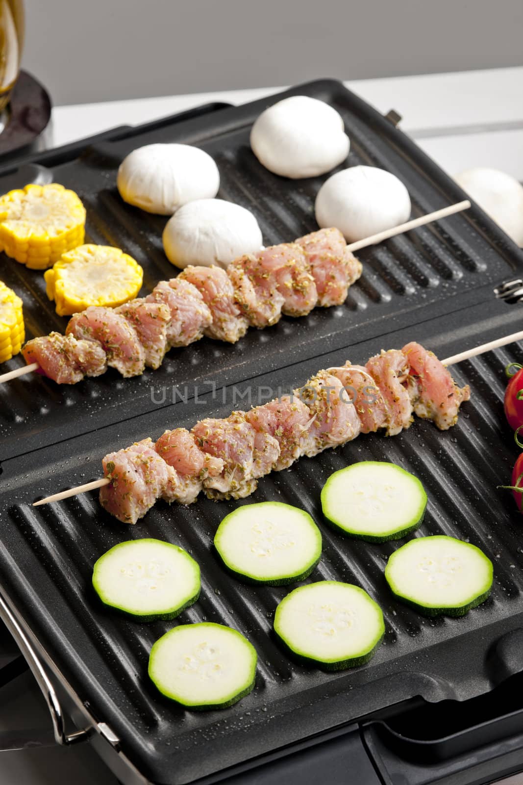 meat skewers and vegetables on electric grill by phbcz