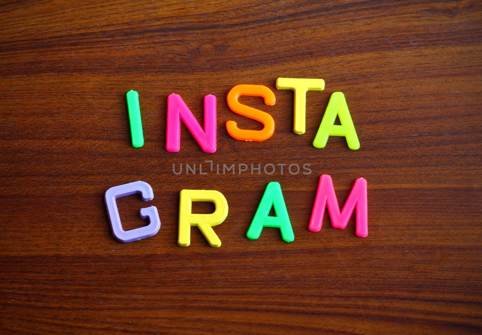 Instagram in colorful toy letters on wood background
