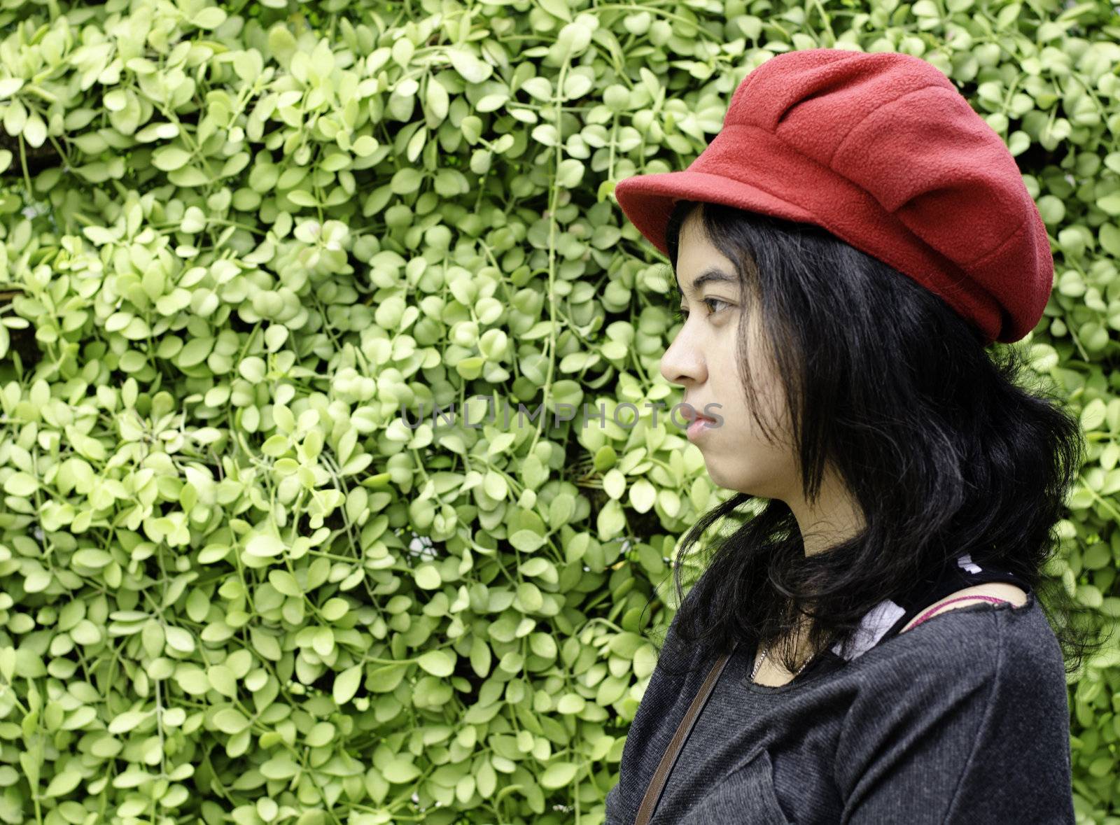 Asian girl with red hat on a background of green nature  by siraanamwong