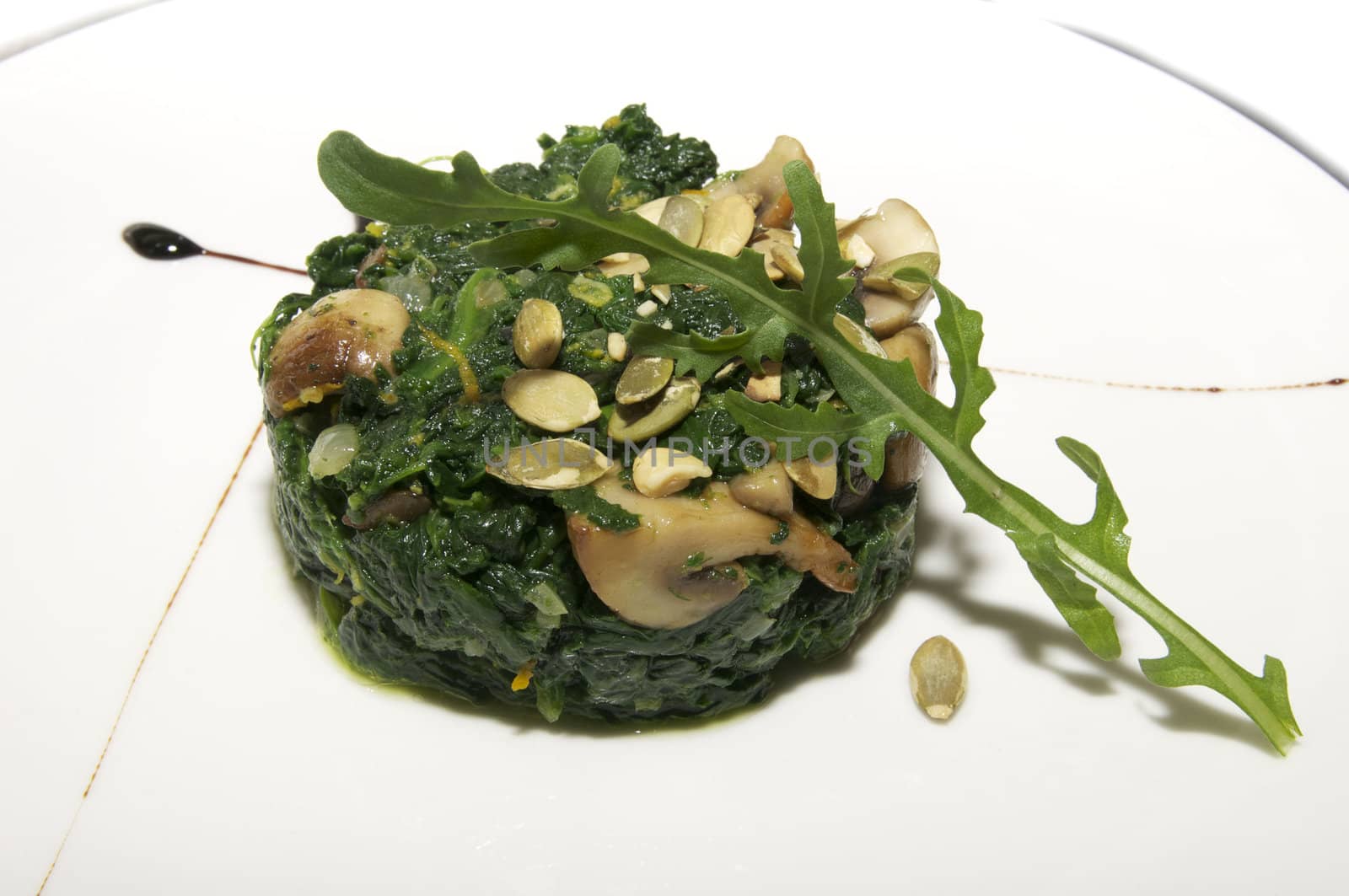 a salad of beans and mushrooms on a plate decorated with greens