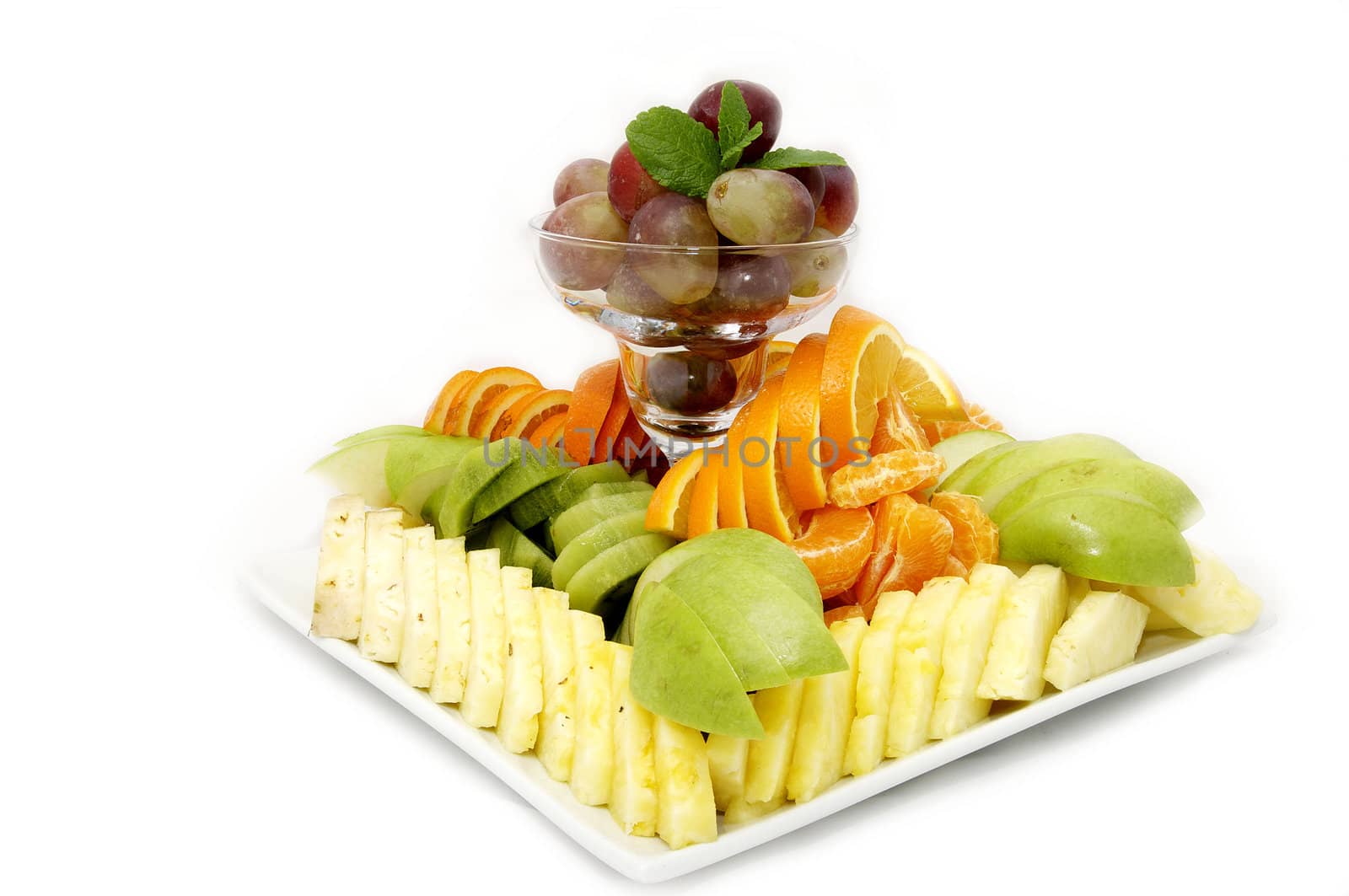 a plate of beautifully sliced fruit on white background