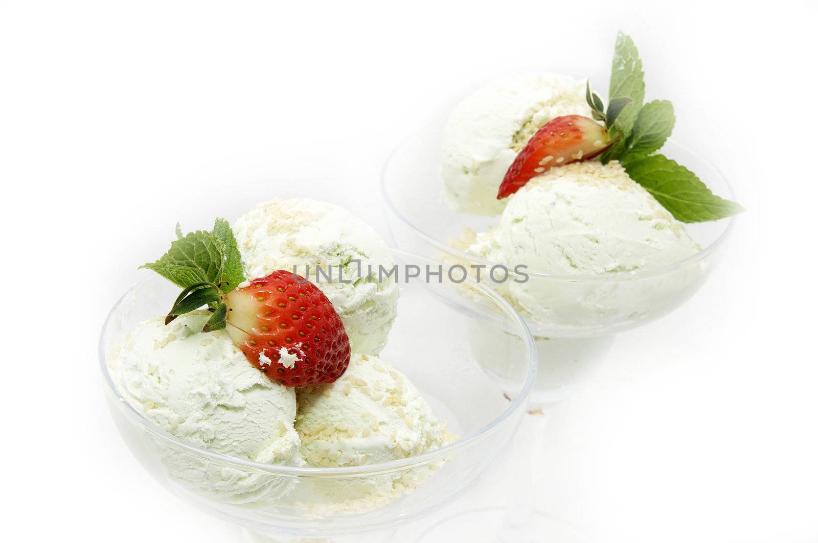 two cups of ice cream with strawberries on a white background
