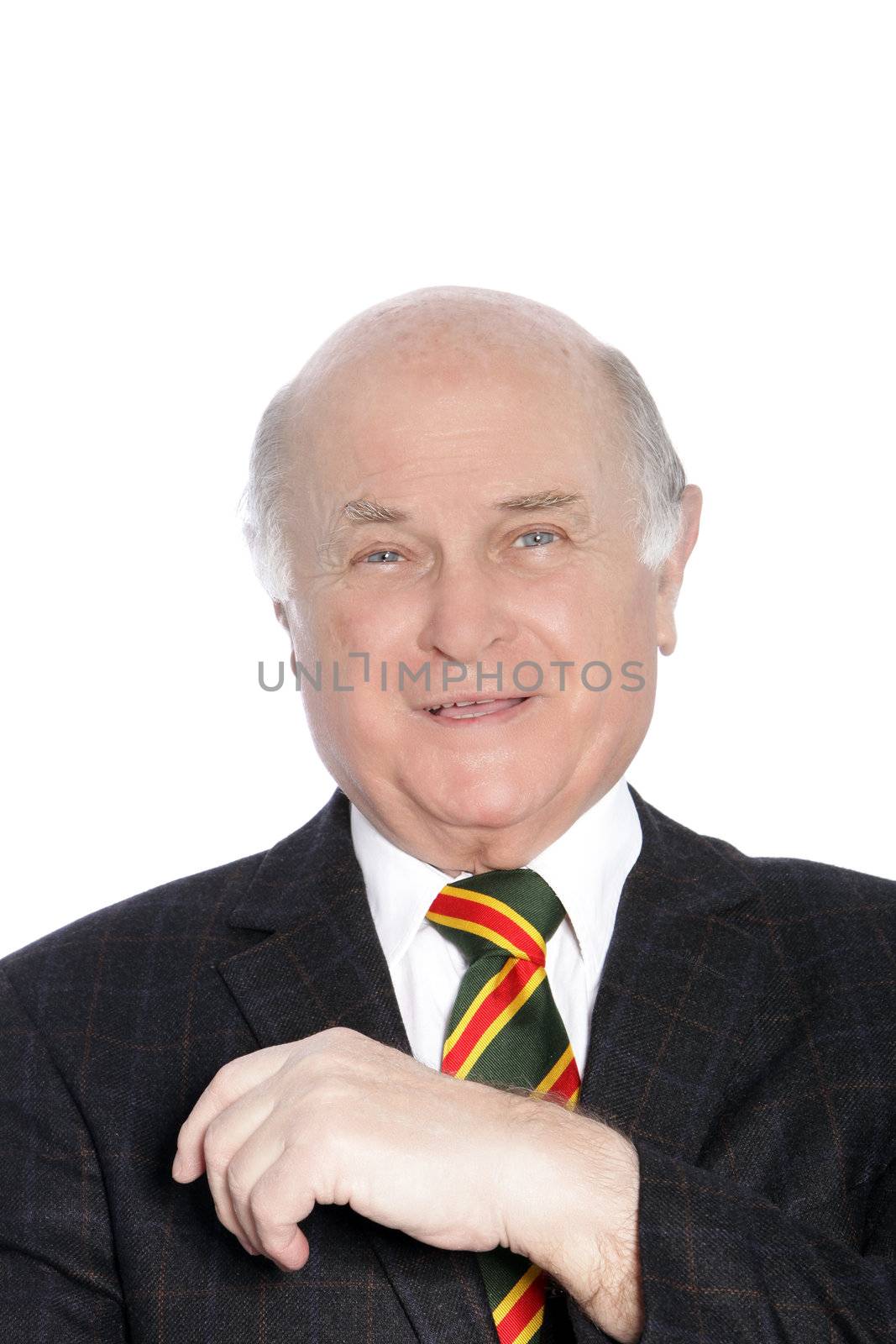 Head and shoulders portrait of a stylish elderly gentleman in a jacket and colourful tie smiling at the camera isolated on white