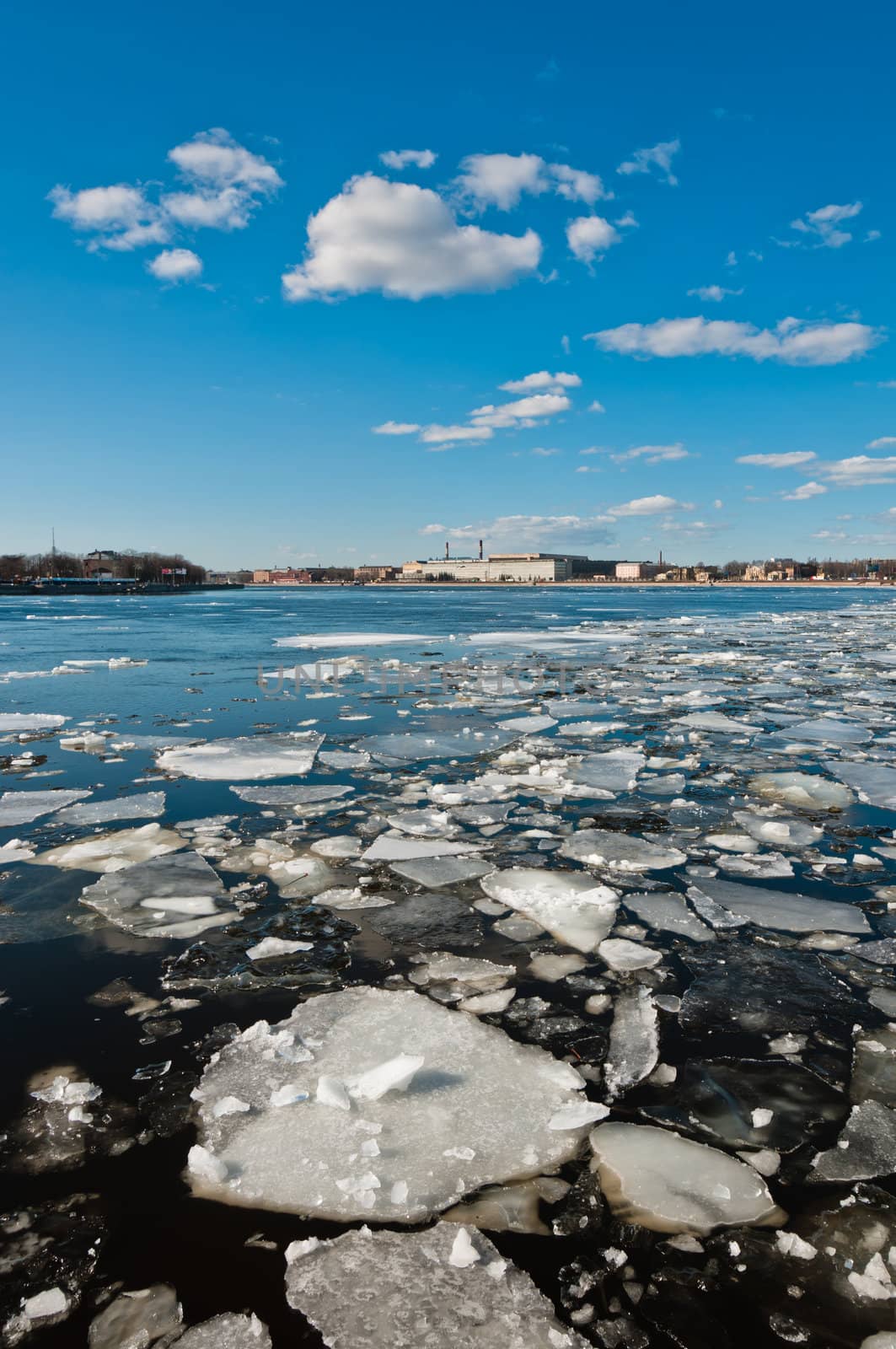 Small and broken ice pieces floating on river in city