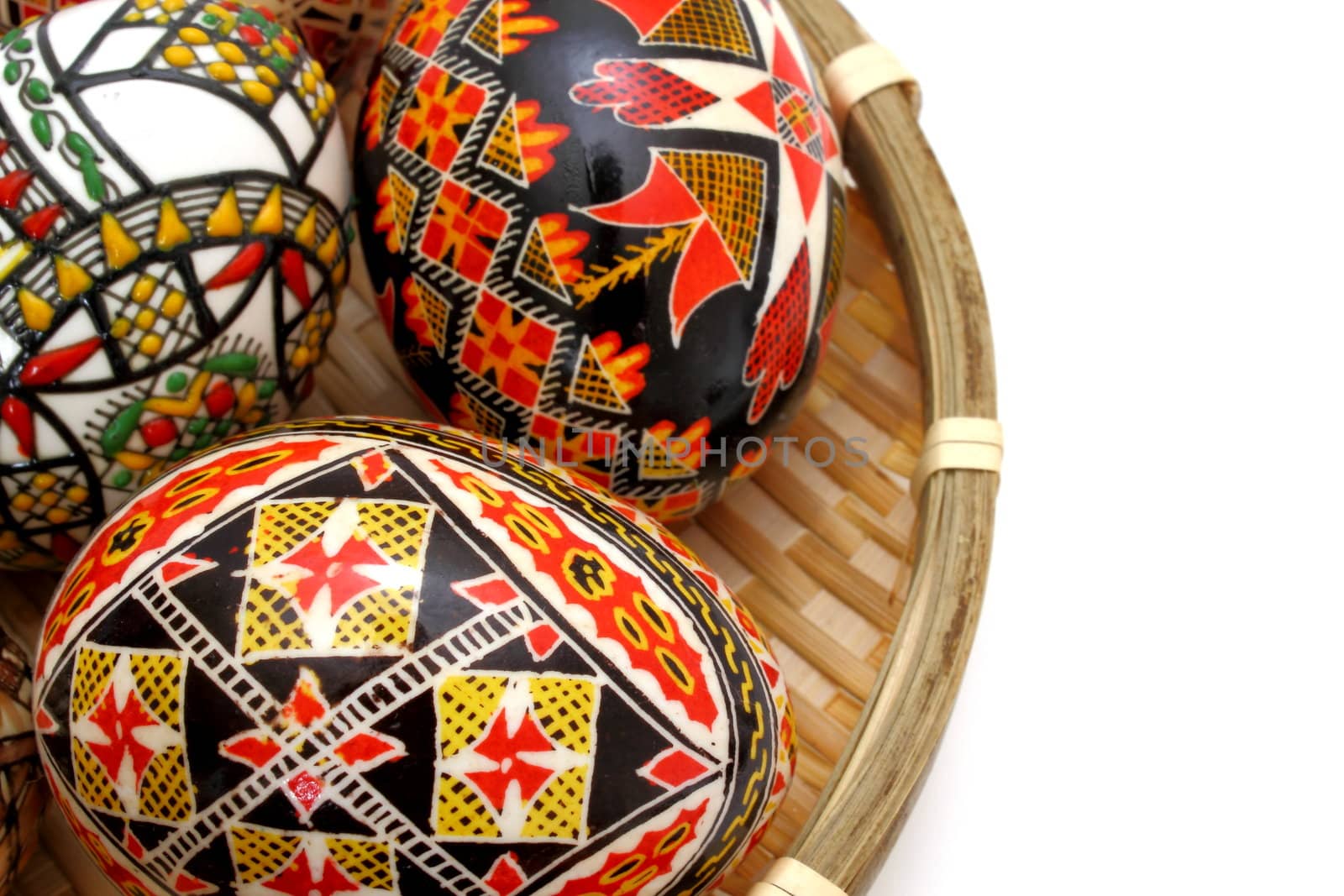 hand painted eggs in trellis basket over white background