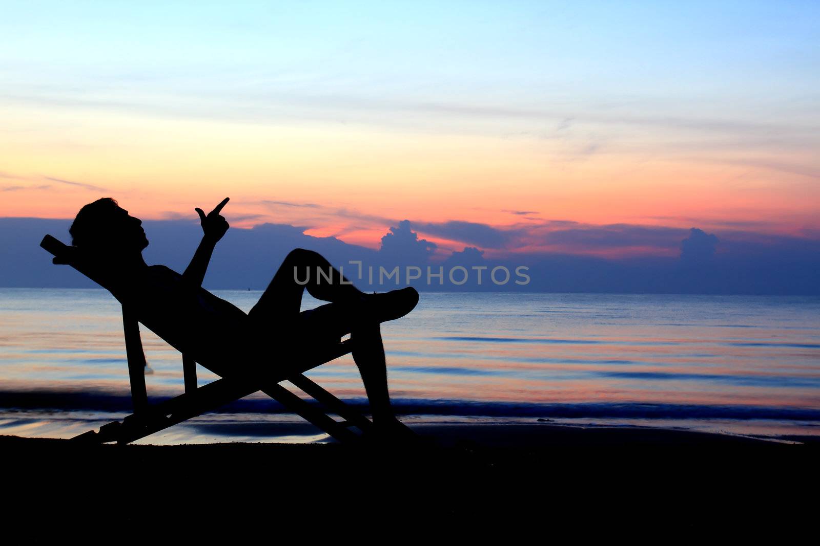   deckchairs and man on beach at sunset 
 by rufous