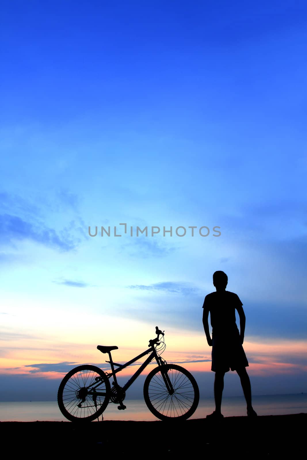 Silhouette of man riding bicycle with beautiful lake near by at  by rufous