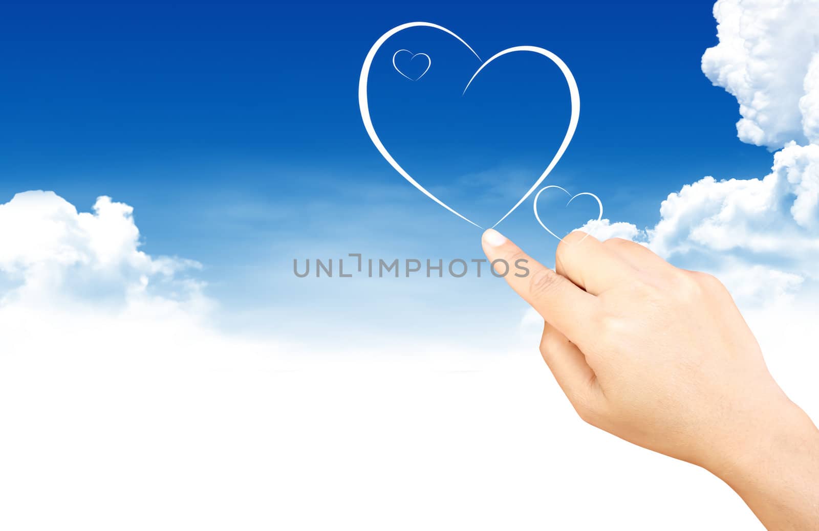 Hand holding heart shape cloud and blue sky