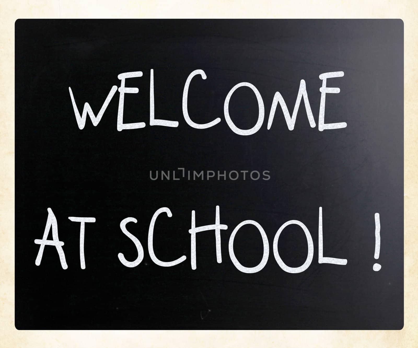 "Welcome at school" handwritten with white chalk on a blackboard