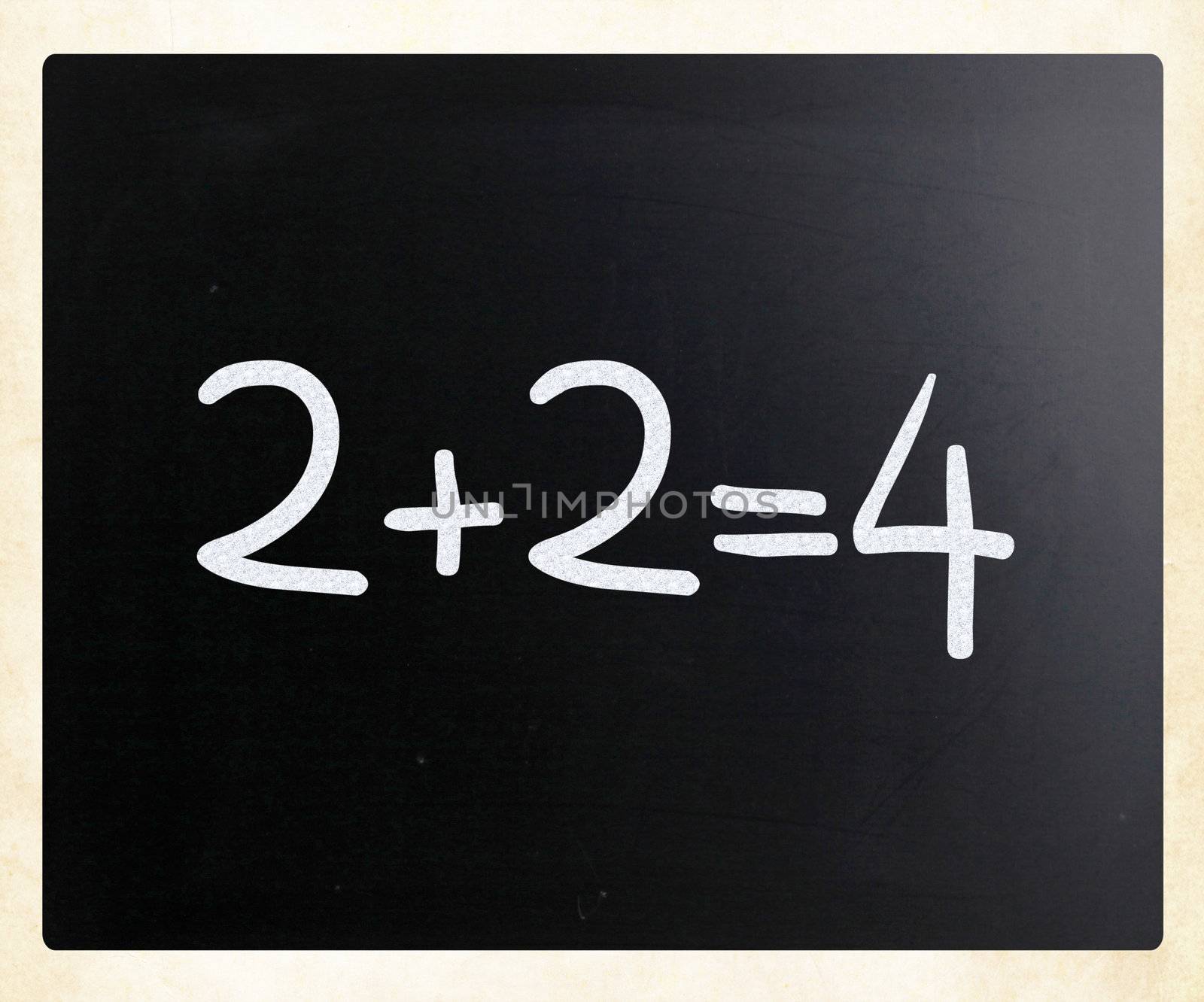 "2+2=4" handwritten with white chalk on a blackboard