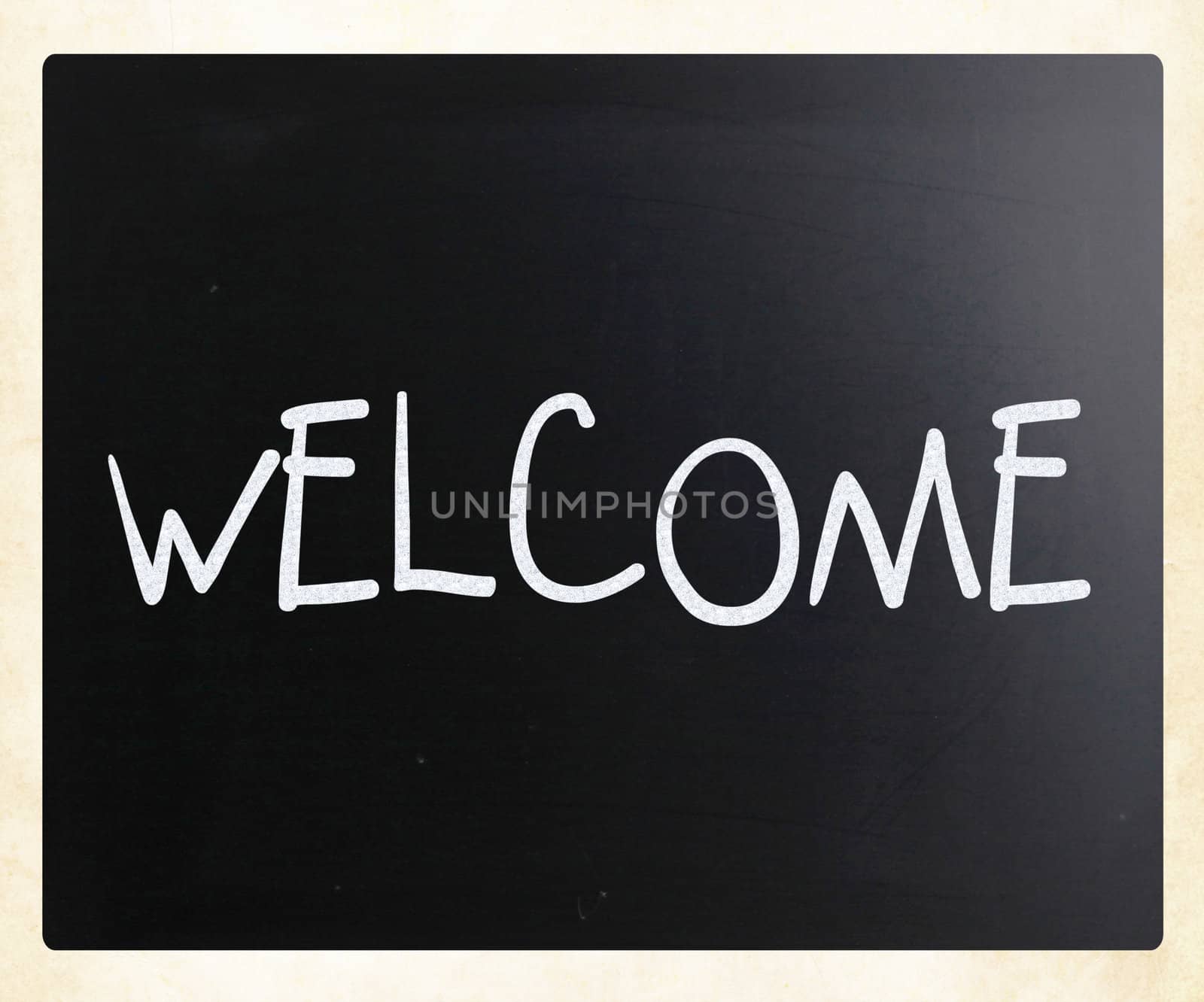 "Welcome" handwritten with white chalk on a blackboard